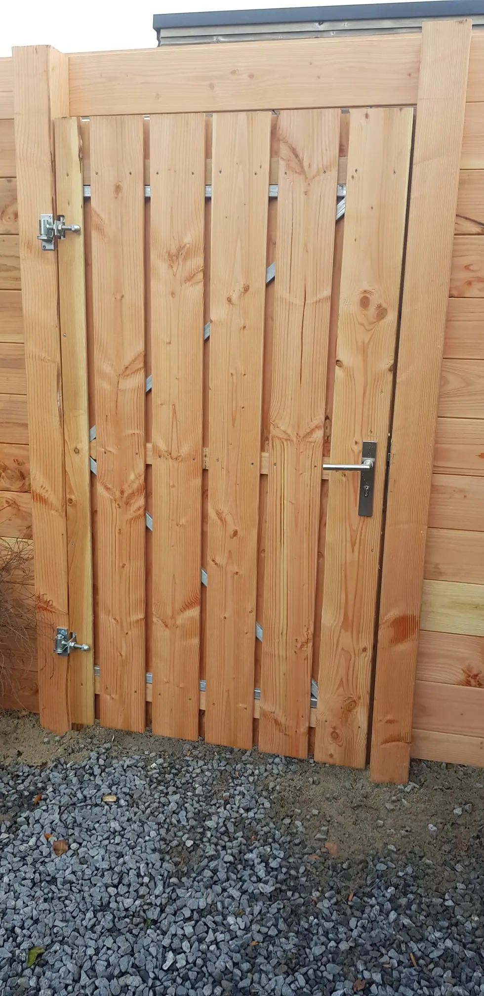 Houten tuinpoort in een schutting